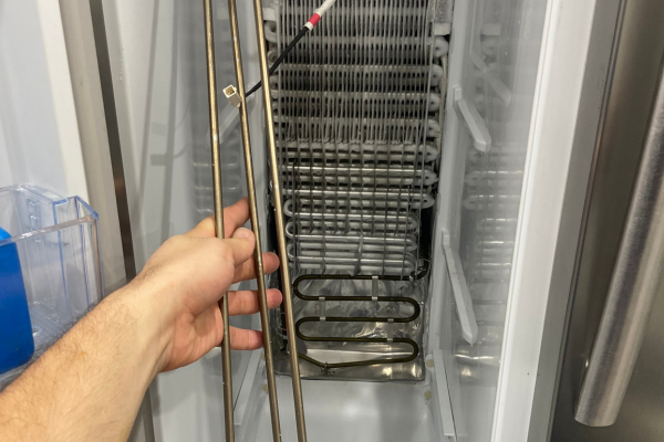 Technician inspecting freezer evaporator coils during freezer repair in Adelaide