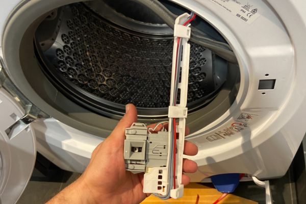 Technician repairing a front load dryer component in Adelaide home