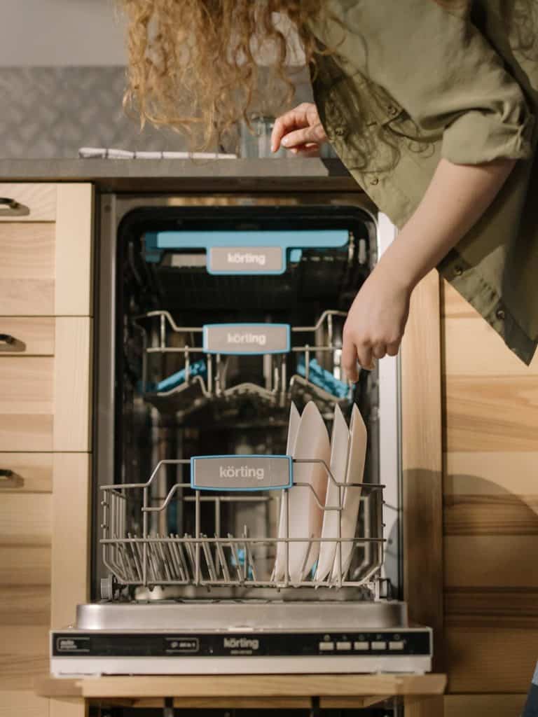woman sorting plates, looking at the dishwasher, How much does a dishwasher repair cost in Australia