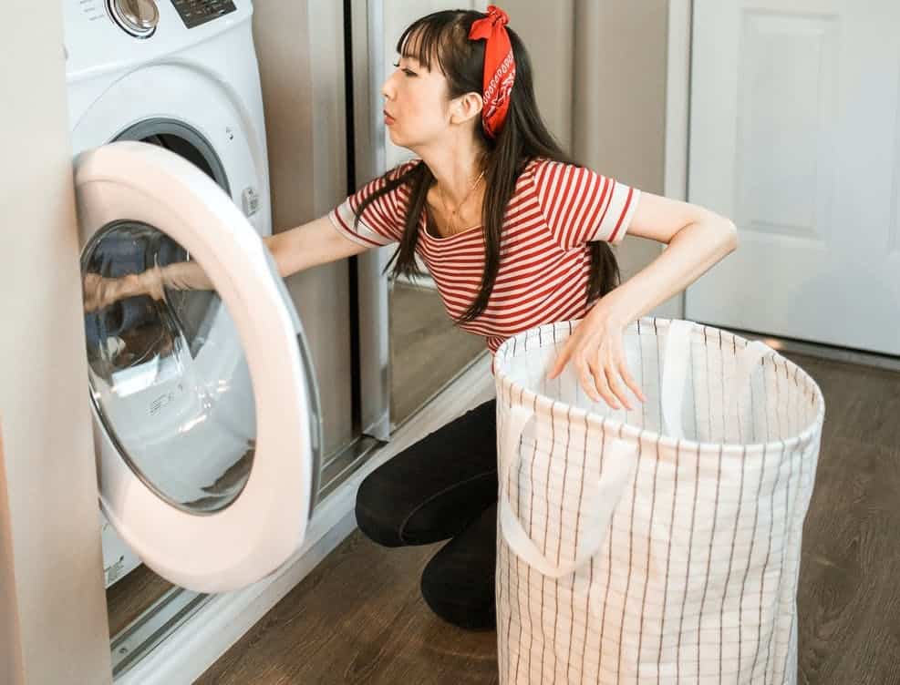 woman getting the clothes inside the dryer, noisy dryer