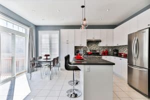 fridge in the kitchen with other appliances such as stove, oven, and small appliances