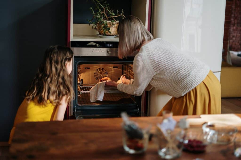 mother and daughter baking on the oven, oven repair cost in australia