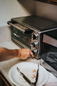 hands in the oven temperature, checking if the oven is working properly.