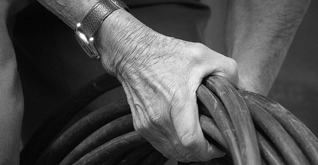 A hand holding a water supply line