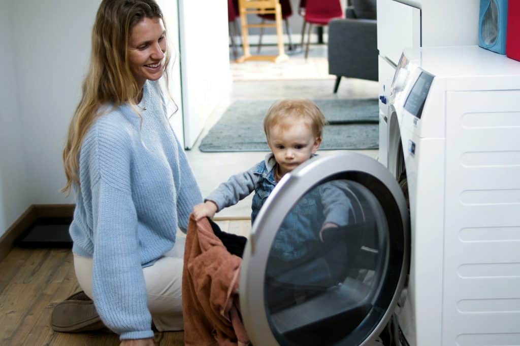 A mother and child doing laundry with their washing machine, common issues and solution